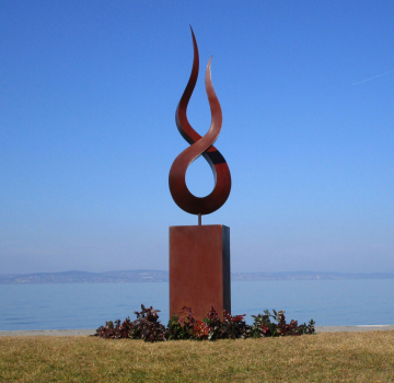 Stainless steel flame artwork on rusty column